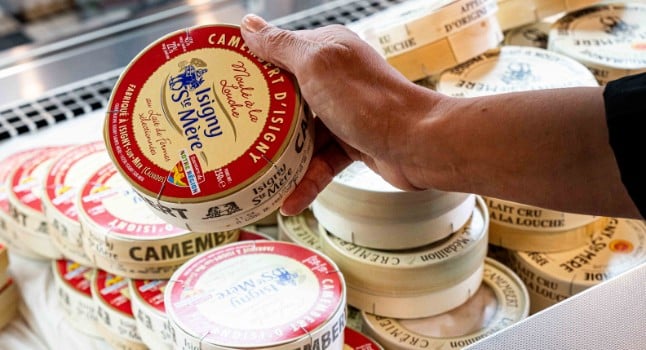 Une main en train de saisir un Camembert