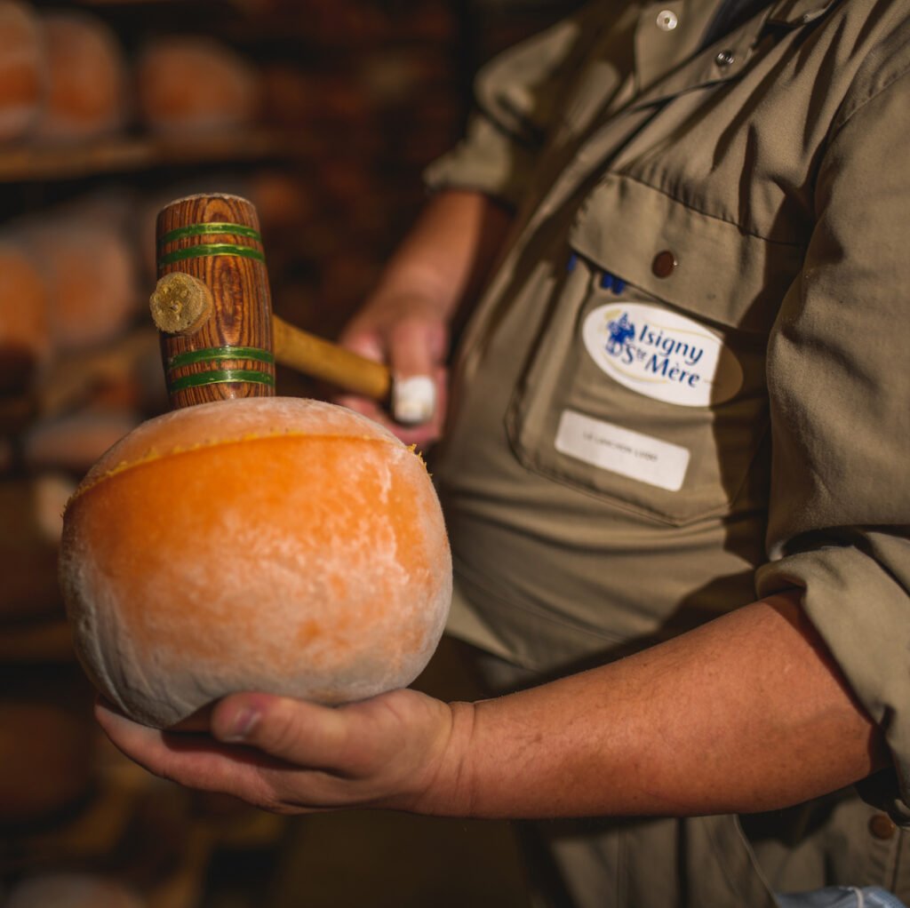 Sonneur de mimolette, avec une mimolette dans la main