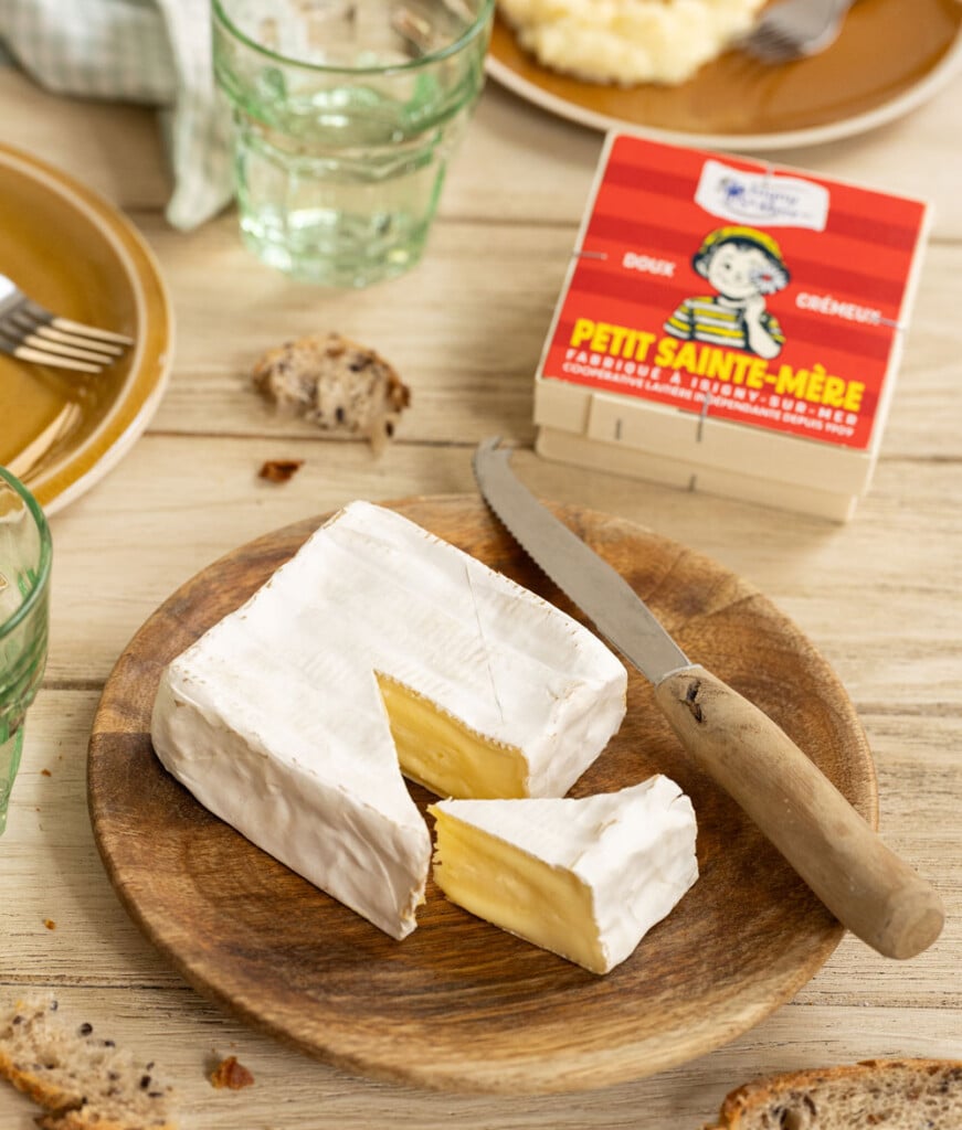 Fromage petit Sainte-Mère sur une table dans une assiette avec l'emballage à côté. Moment de fin de repas.