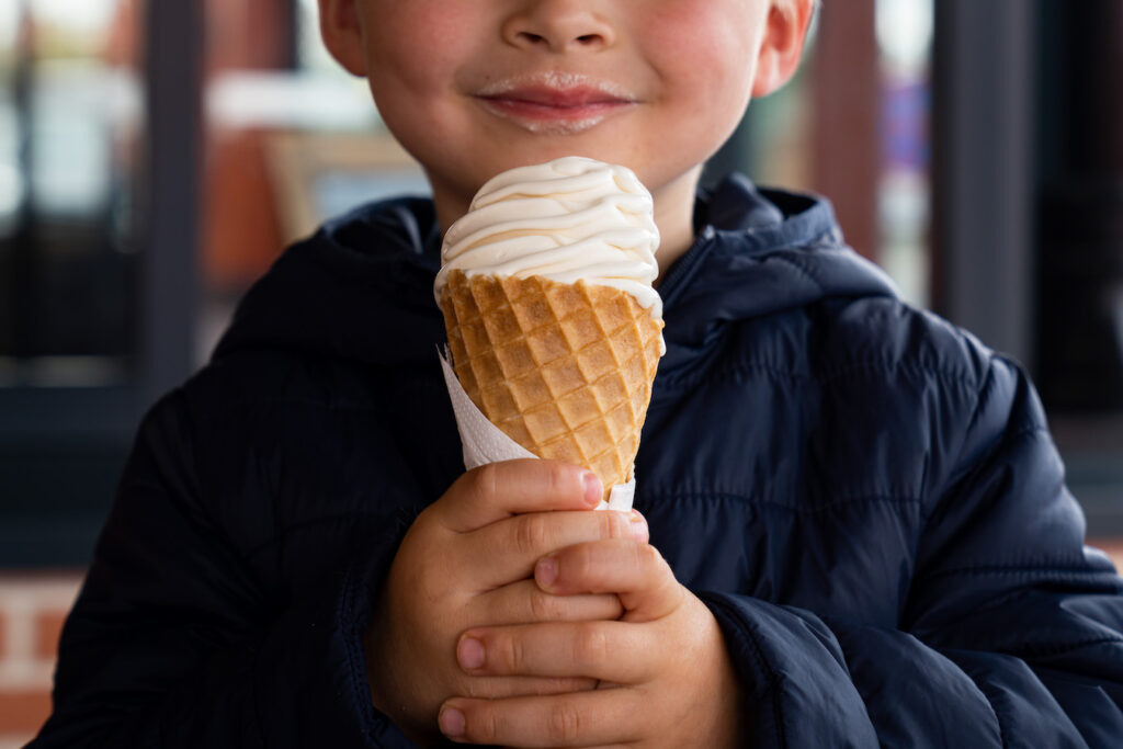 Enfant qui tient une glace à la crème dans ses mains