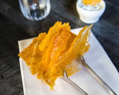 Chips de pommes de terra à la Mimolette Isigny Sainte-Mère sur une assiette