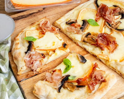 Pinsa au Pavé d'Isigny sur une planche à découper